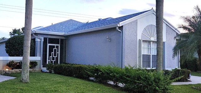 single story home featuring a garage and a front lawn