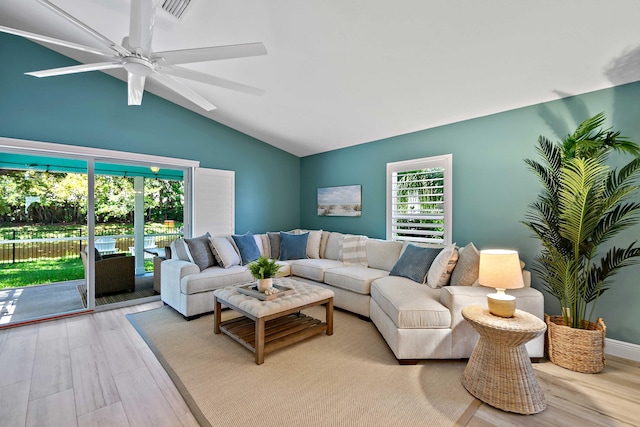 living room featuring ceiling fan, vaulted ceiling, and light hardwood / wood-style flooring