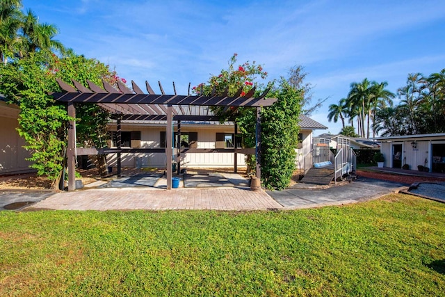 back of house featuring a pergola, a patio area, and a yard