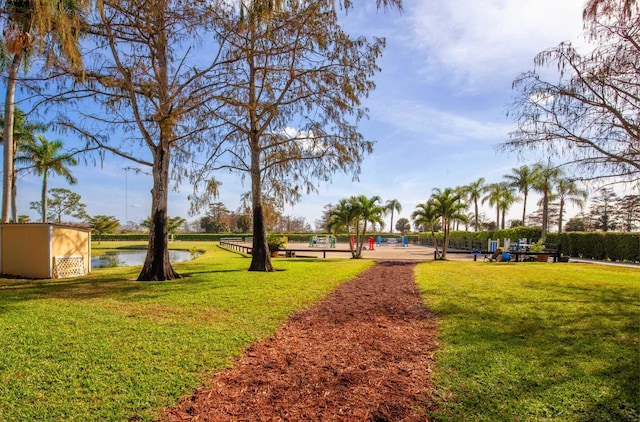 view of property's community with a water view and a yard