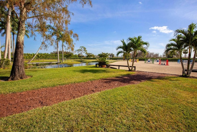 view of home's community featuring a water view and a lawn