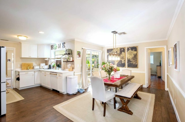 dining area featuring crown molding, dark hardwood / wood-style flooring, and sink