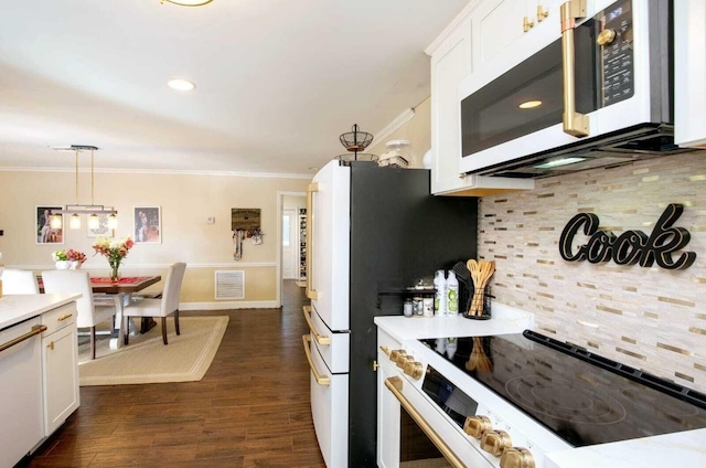 kitchen with tasteful backsplash, white cabinetry, pendant lighting, and range