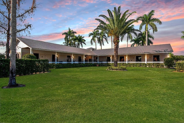 back house at dusk with a lawn