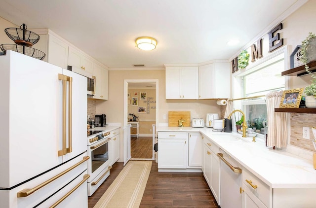 kitchen with sink, dark wood-type flooring, tasteful backsplash, white appliances, and white cabinets