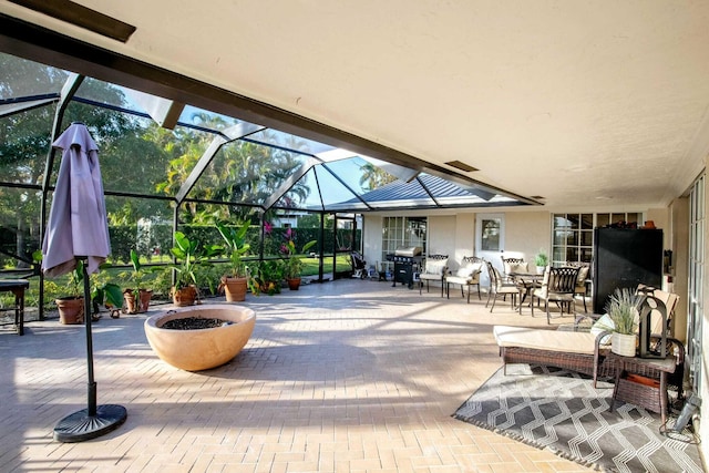 view of patio featuring area for grilling and glass enclosure