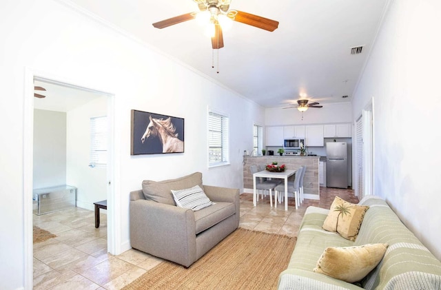 living room with light tile patterned flooring and ornamental molding