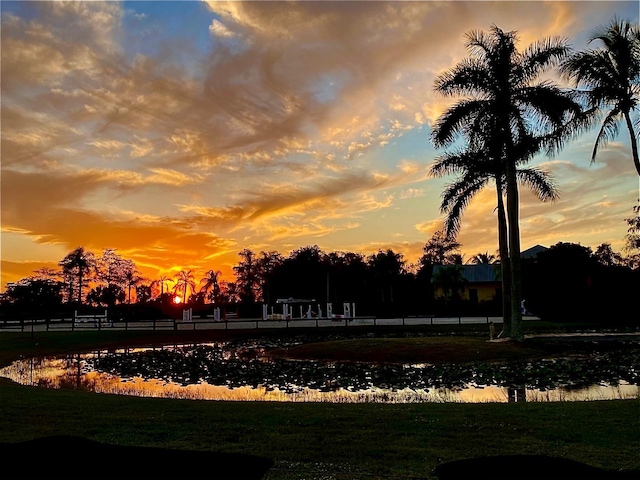 yard at dusk featuring a water view