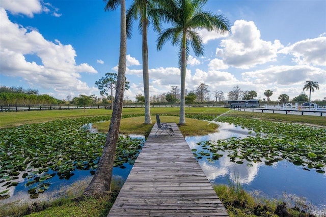 dock area featuring a lawn and a water view