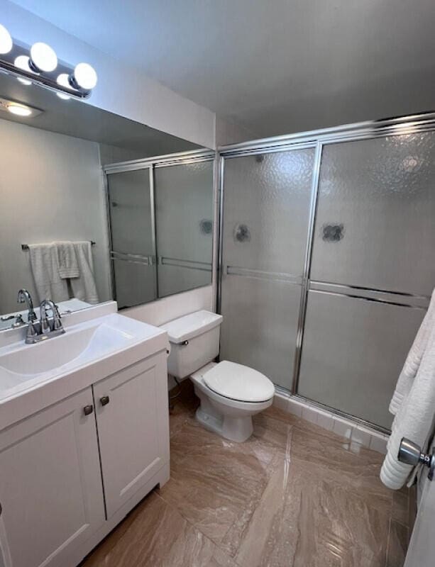 bathroom with toilet, vanity, and walk in shower