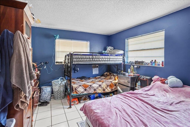 bedroom featuring light tile patterned flooring and a textured ceiling