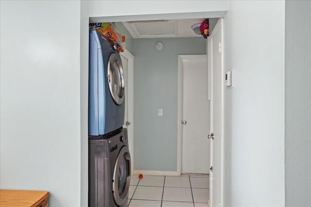 washroom with light tile patterned flooring and stacked washer and clothes dryer