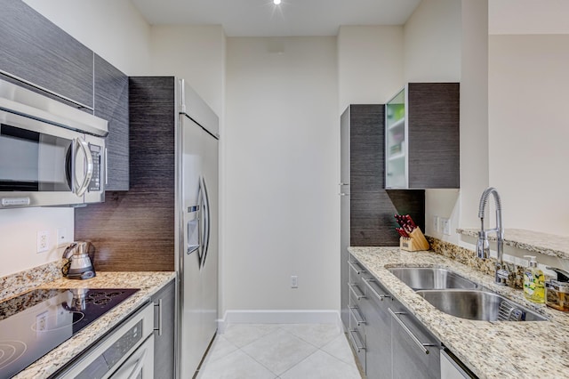 550 Okeechobee Blvd Unit Lph-12, West Palm Beach, FL 33401 - kitchen featuring built in fridge, stainless steel microwave, light tile patterned floors, light stone countertops, and black electric cooktop