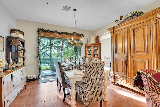 tiled dining room featuring an inviting chandelier