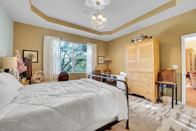 bedroom featuring baseboards, a tray ceiling, visible vents, and an inviting chandelier