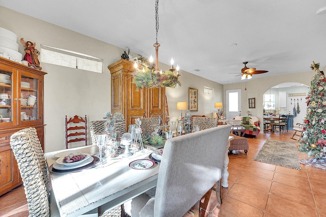 tiled dining area featuring ceiling fan with notable chandelier