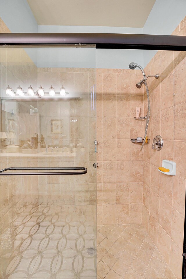 bedroom featuring a chandelier, a raised ceiling, and ensuite bath