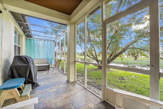 unfurnished sunroom featuring a water view and a healthy amount of sunlight