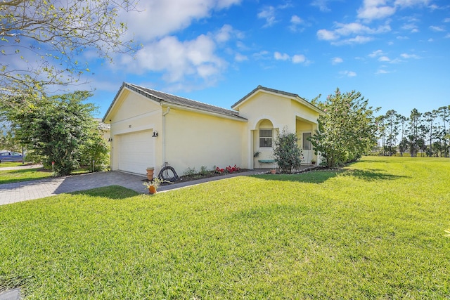 view of front of property featuring a garage, stucco siding, decorative driveway, and a front yard