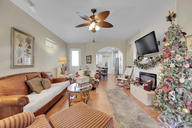 living room with ceiling fan, a fireplace, and light tile patterned floors