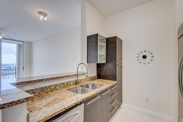 kitchen with light stone counters, stainless steel dishwasher, ceiling fan, sink, and a wall of windows