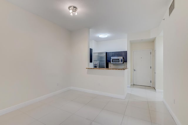 spare room featuring light tile patterned flooring