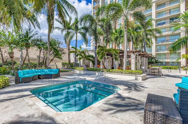 view of swimming pool with outdoor lounge area, a patio, and a hot tub