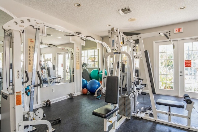 gym featuring french doors and a textured ceiling