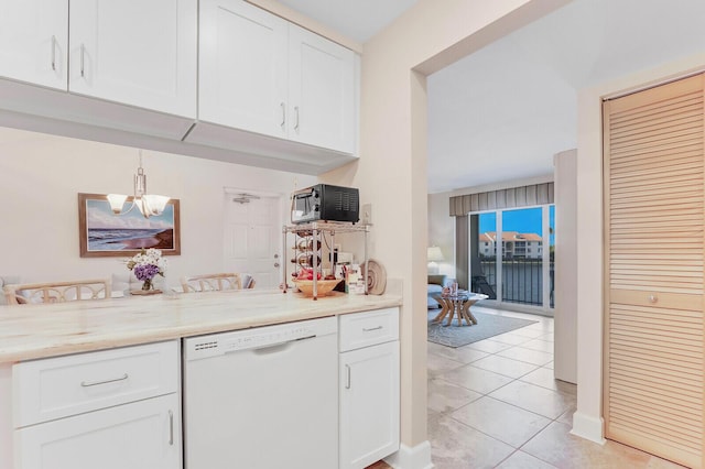 kitchen featuring pendant lighting, dishwasher, light tile patterned flooring, light stone counters, and white cabinetry