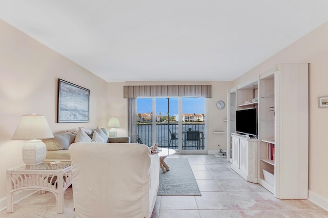 living room featuring built in shelves and light tile patterned floors