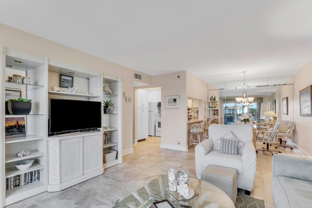 living room featuring built in shelves and a notable chandelier