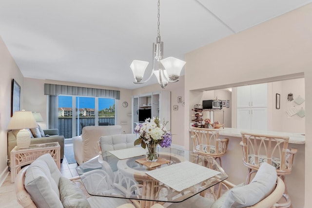 dining space featuring light tile patterned floors and a notable chandelier