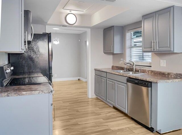 kitchen with light wood-type flooring, stainless steel dishwasher, sink, electric range, and gray cabinets