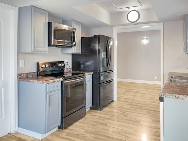 kitchen with sink, light hardwood / wood-style flooring, gray cabinets, pendant lighting, and electric stove