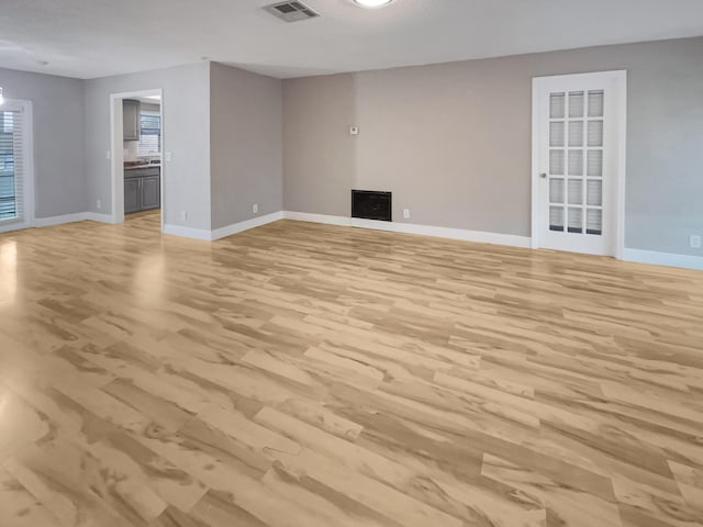 unfurnished living room with light hardwood / wood-style floors and a textured ceiling