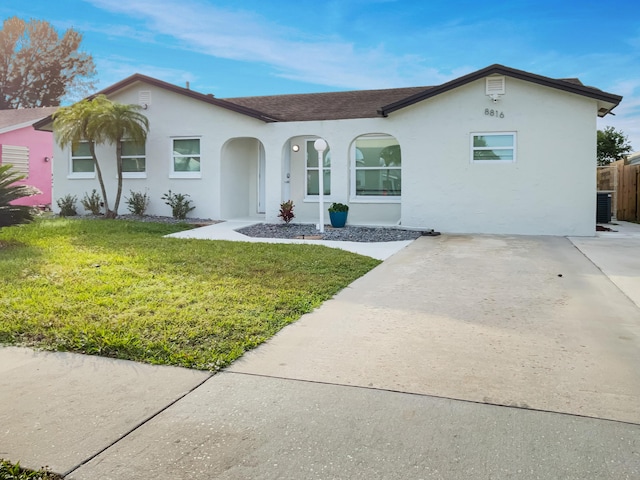 ranch-style home featuring cooling unit and a front yard