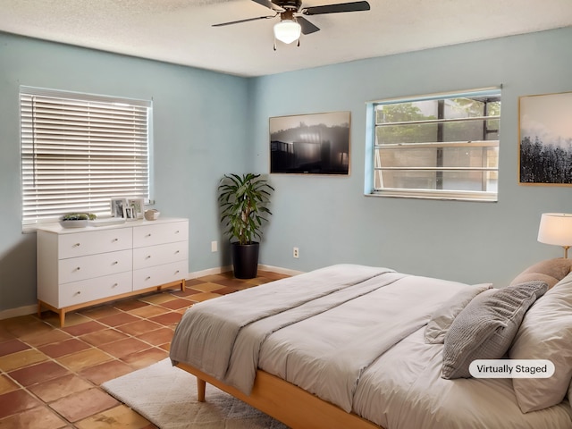 bedroom with multiple windows, tile patterned flooring, and ceiling fan