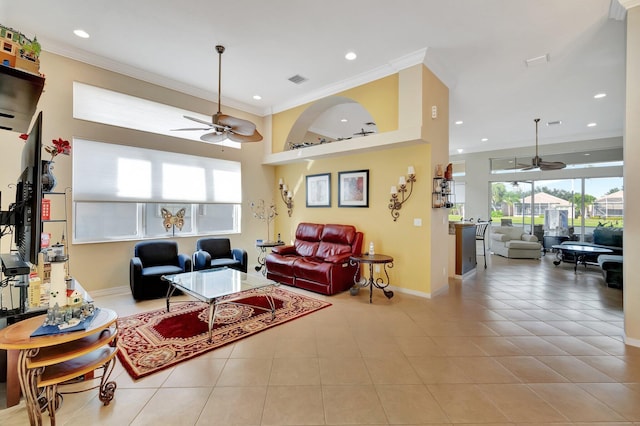 living room with ceiling fan, ornamental molding, and light tile patterned floors