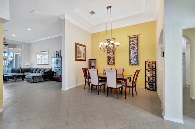 tiled dining room featuring a raised ceiling, crown molding, and an inviting chandelier