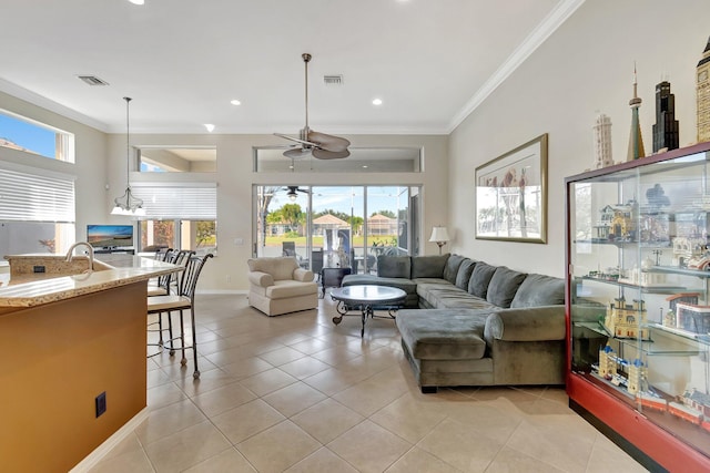 living room featuring plenty of natural light, ceiling fan, light tile patterned floors, and crown molding