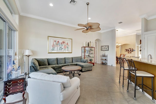 tiled living room featuring ceiling fan with notable chandelier and crown molding