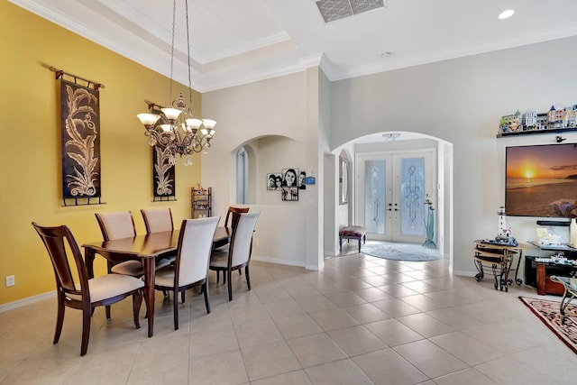 dining space with an inviting chandelier, light tile patterned flooring, ornamental molding, and french doors