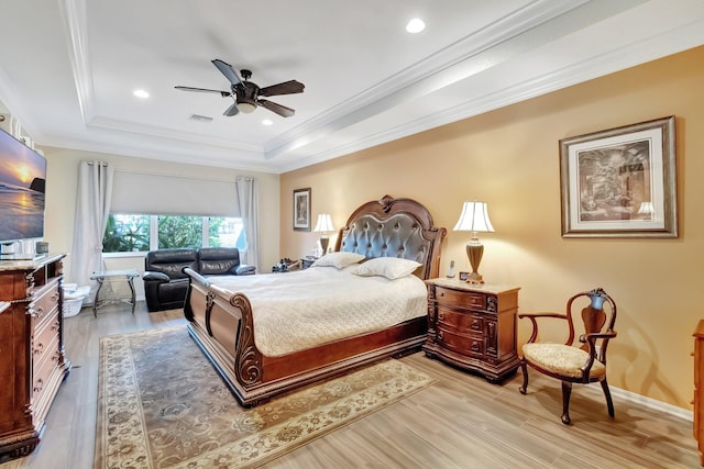 bedroom with a raised ceiling, ceiling fan, light hardwood / wood-style floors, and ornamental molding