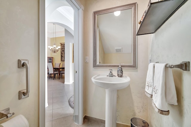 bathroom featuring tile patterned flooring, an inviting chandelier, and ornamental molding