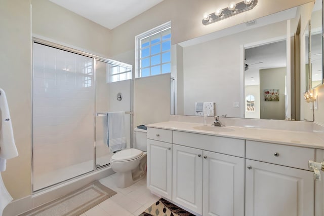 bathroom with vanity, tile patterned flooring, ceiling fan, toilet, and a shower with shower door