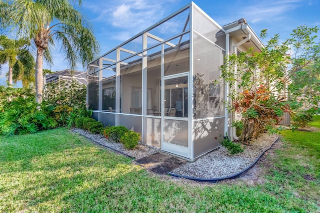 view of property exterior with a lawn and glass enclosure