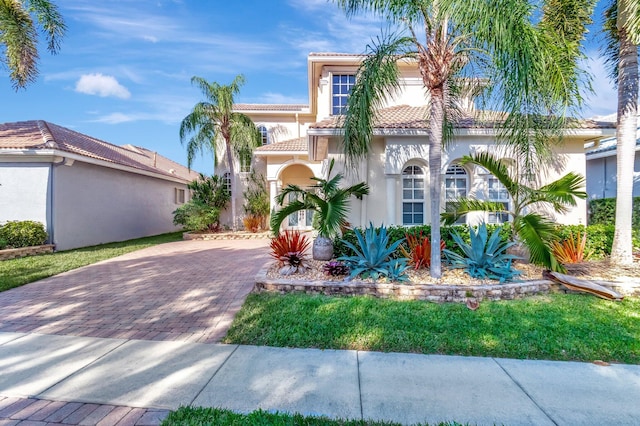 mediterranean / spanish house featuring a front yard