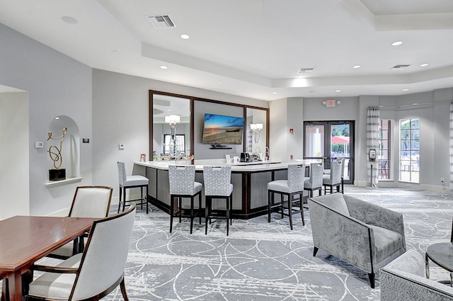 dining area featuring a raised ceiling and french doors