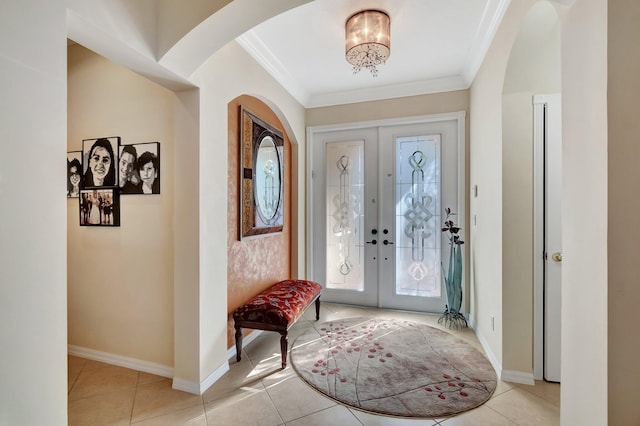 tiled foyer with french doors, an inviting chandelier, and ornamental molding