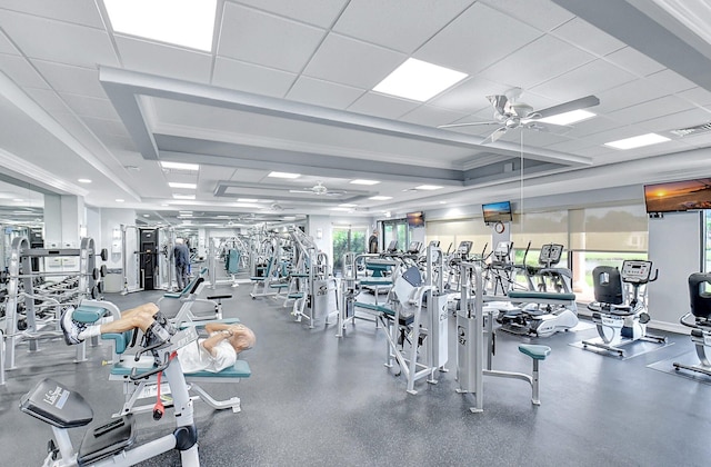 exercise room with a paneled ceiling and ceiling fan